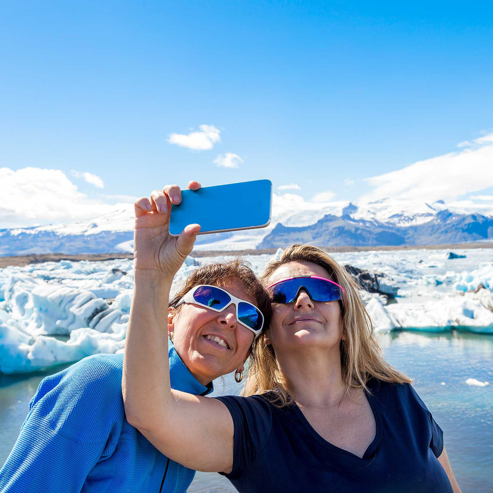 two female tourists taking a selfie with a smart phone