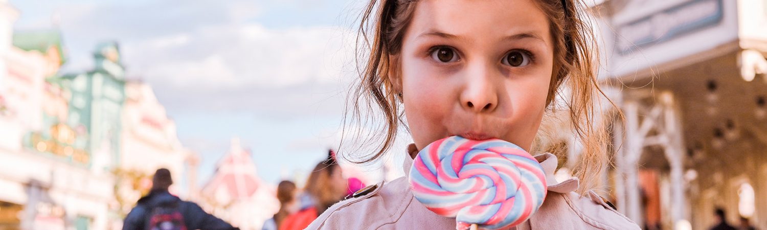 Little girl with big lollipop is playing and having fun in the p